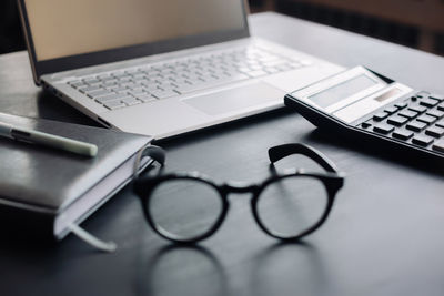 High angle view of laptop and calculator on table