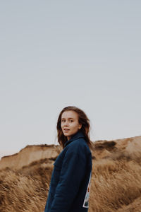 Portrait of a smiling young woman against clear sky