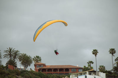 Low angle view of person paragliding against sky