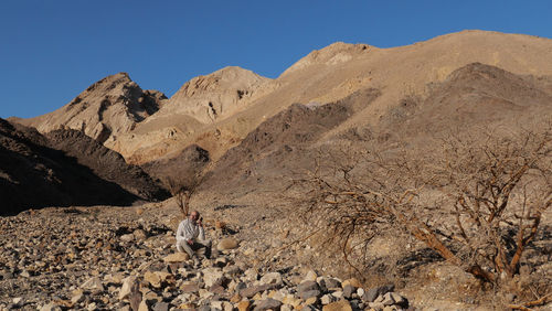 Senior man in the desert with smart phone 