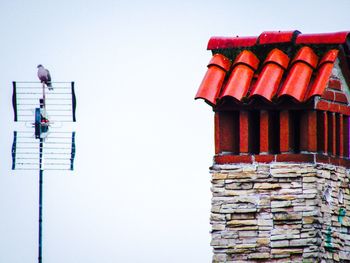 Low angle view of multi colored roof against building against clear sky