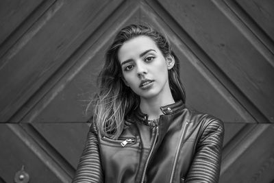 Close-up portrait of woman standing against entrance of building