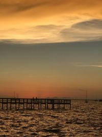 Silhouette pier on sea against sky during sunset