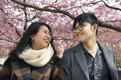 Smiling couple under cherry blossom
