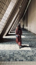 Rear view of woman walking in corridor