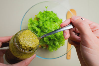 Delicious appetizing fresh salad with pesto sauce in a glass bowl on a light background. view from