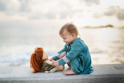 Girl playing with a doll in summer