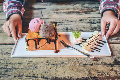 Midsection of man holding ice cream on table