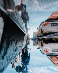 Boats moored on canal in city against sky