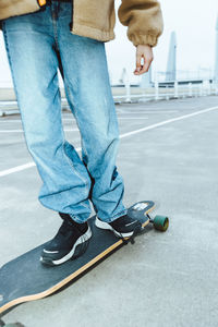 Low section of girl skateboarding on street during weekend