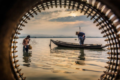 Men on boat in sea against sky