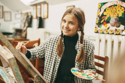 Portrait of girl painting at classroom