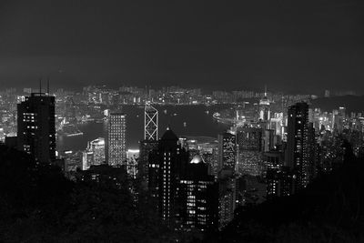 Illuminated buildings in city against sky at night