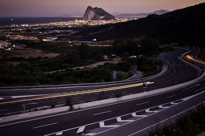 High angle view of light trails on two lane highway at dusk