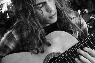 Close-up of young woman playing guitar