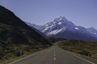 Road amidst mountains against clear sky