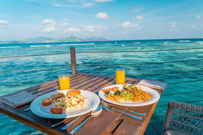 Food on table by swimming pool against sea, la digue seychelles 