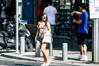 Full length of woman with arms raised in city