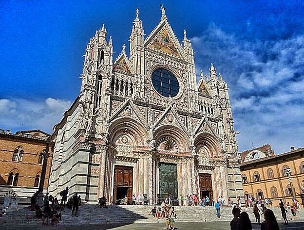 place of worship, religion, architecture, building exterior, church, spirituality, built structure, cathedral, famous place, sky, travel destinations, tourism, travel, facade, large group of people, international landmark, person