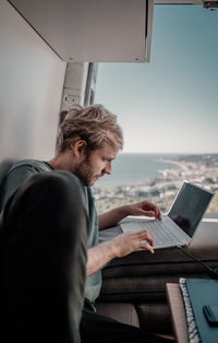 Man working in laptop sitting outdoors