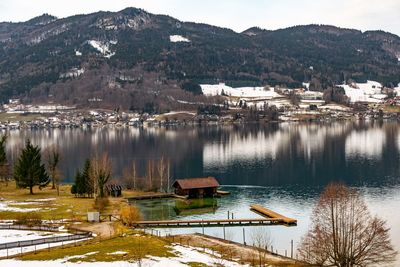 Scenic view of lake by buildings and mountains