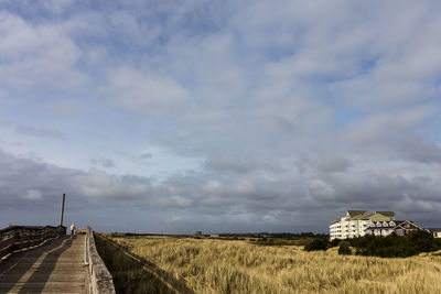 Road amidst field against sky