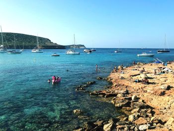 Sailboats on sea against clear sky