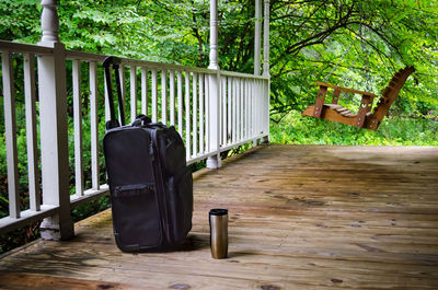 Chair on railing against trees