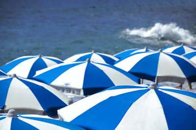 Umbrellas on beach against blue sky