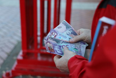 Close-up of hand holding red paper