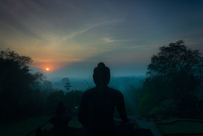 Silhouette statue against sky during sunset