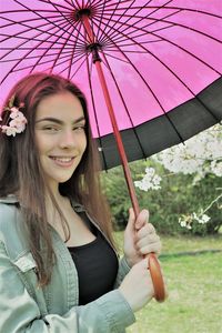 Portrait of smiling young woman holding camera