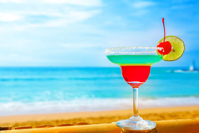 Close-up of beer in glass against sea
