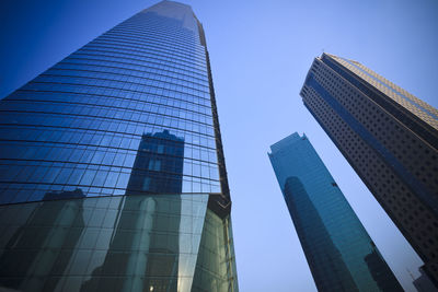 Low angle view of modern buildings against clear blue sky