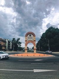 View of city street against cloudy sky