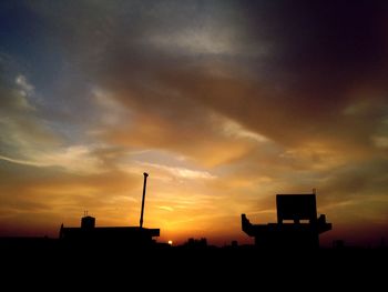 Silhouette of building against sky at sunset