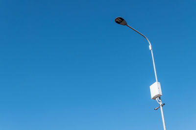 Low angle view of street light against blue sky