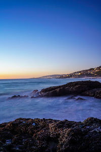 Scenic view of sea against clear sky at sunset