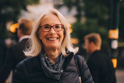 Portrait of smiling senior woman standing in city
