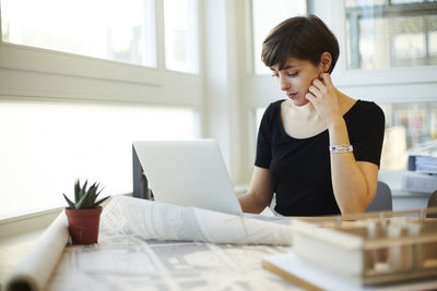 Portrait of architect using laptop in her office