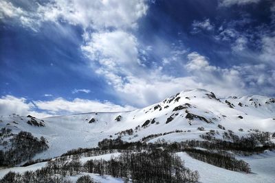 Scenic view of snow covered mountains against sky