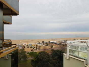 Buildings by sea against sky