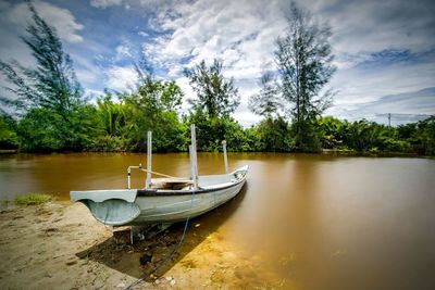 Boats moored in lake against sky
