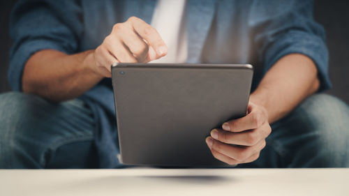 Midsection of man using mobile phone