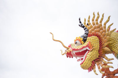 Low angle view of dragon statue against clear sky