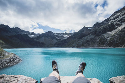 Low section of man at lake against mountains