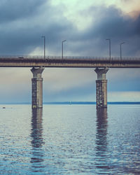 View of bridge over sea against cloudy sky