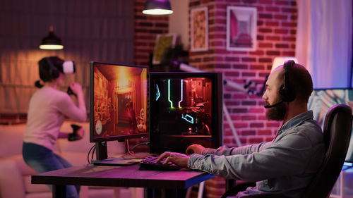 Rear view of woman using laptop at office