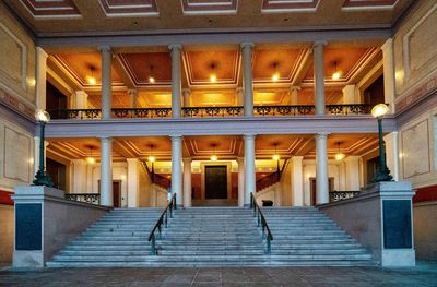 Rear view of illuminated staircase in building at night