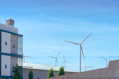 Low angle view of windmill on building against sky